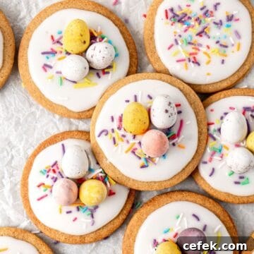 Easy Easter Cookies, decorated with mini eggs and sprinkles, on some baking paper.
