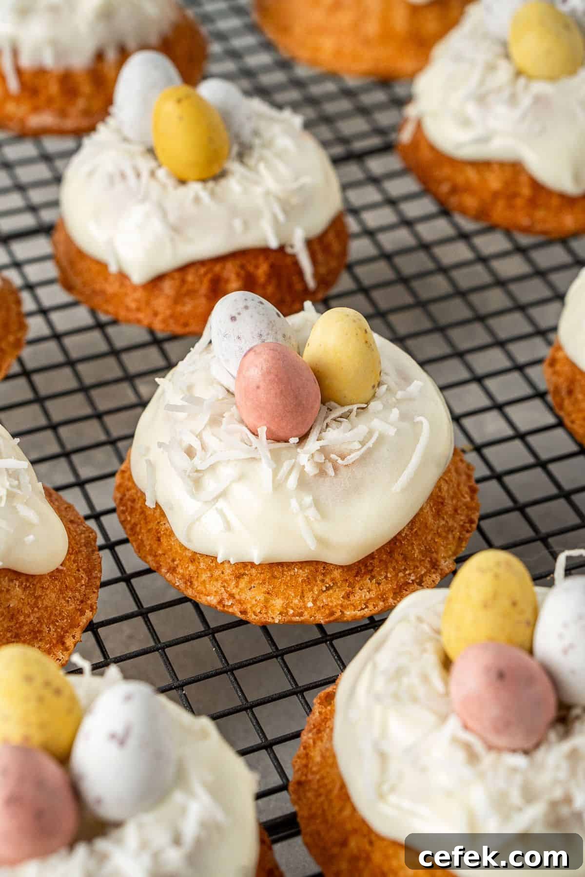 Mini Easter Bundt Cakes, topped with a cream cheese frosting, on a cooling rack.