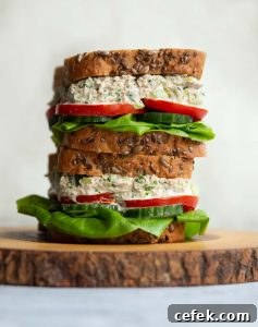 2 sandwiches stacked on each other on wooden board