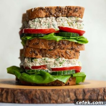 2 sandwiches stacked on each other on wooden board
