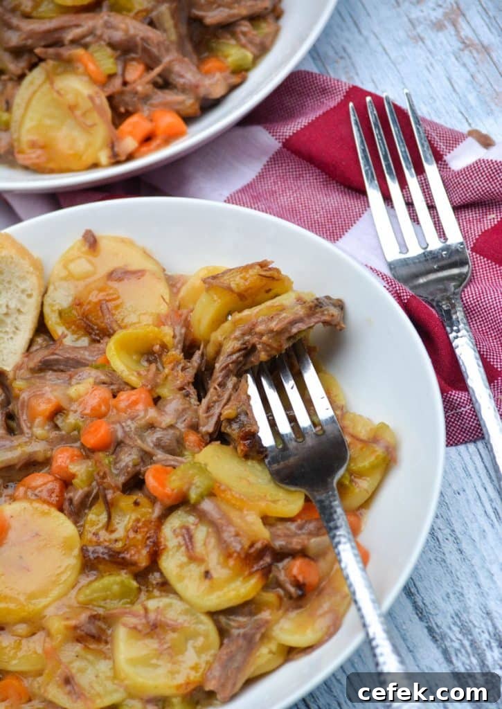 a silver fork digging into a white bowl filled with leftover pot roast casserole
