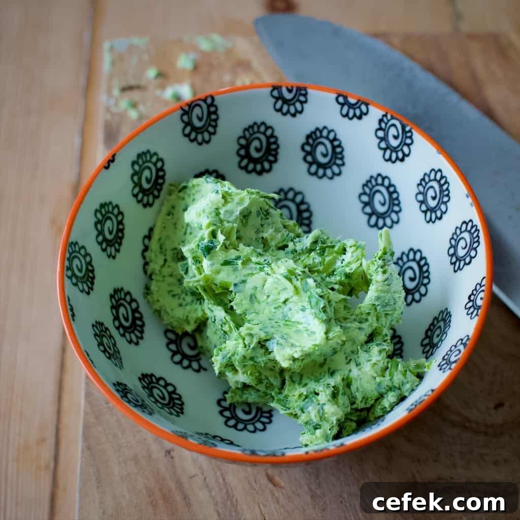 Small white and black bowl filled with bright green wild garlic butter
