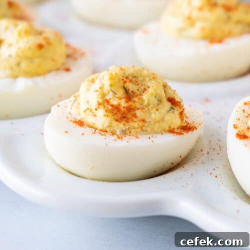 smoked deviled egg with paprika on white platter featured image.