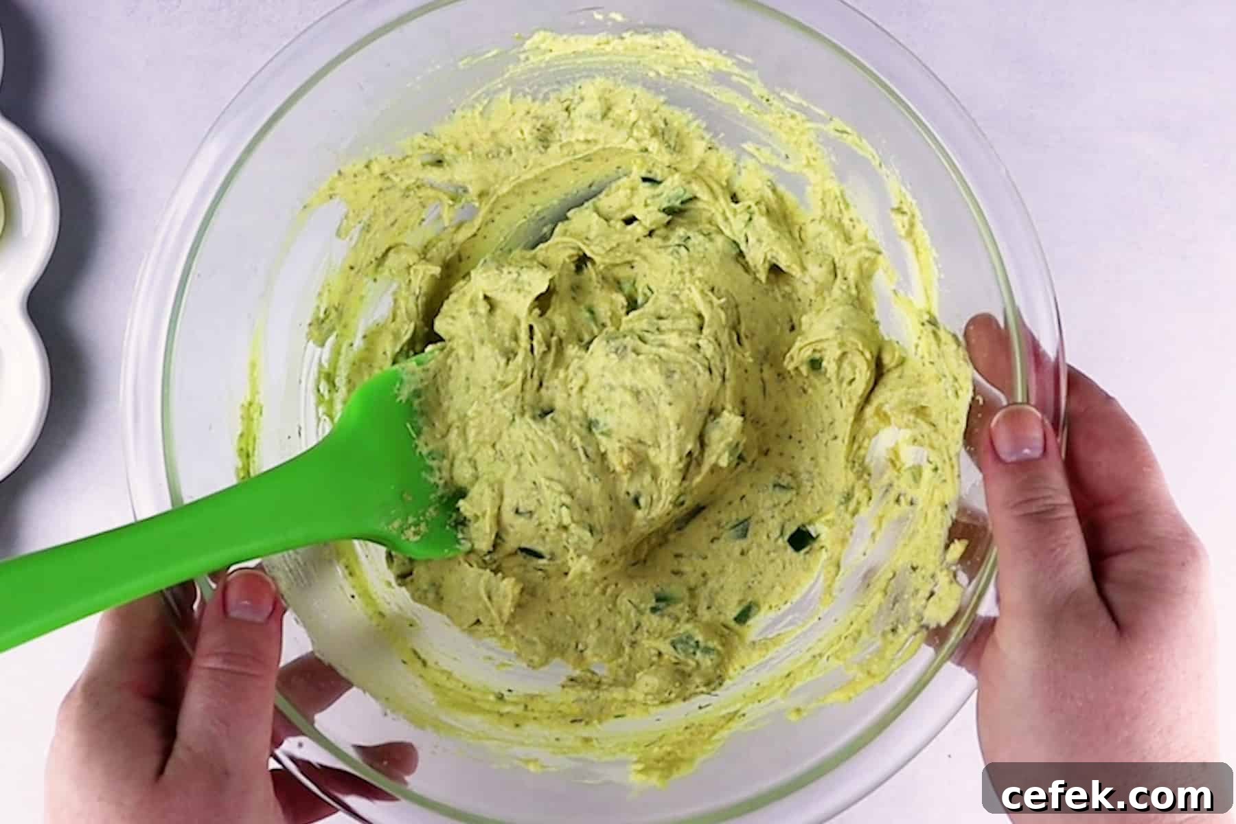 deviled egg yolk mixture mixed with jalapenos in a bowl.