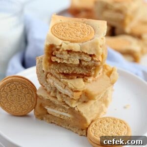 pile of golden oreo blondies on white plate with oreo cookies around