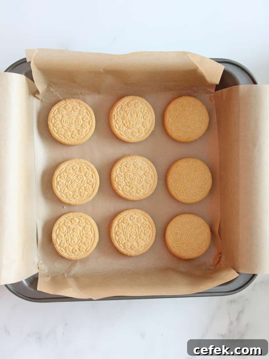 Baking pan with parchment paper and nine Oreo cookies place carefully inside the pan