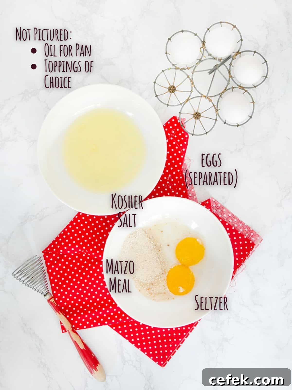 Ingredient shot for matzo meal pancake showing separated eggs in two bowls on a red napkin with an old fashioned whisk.