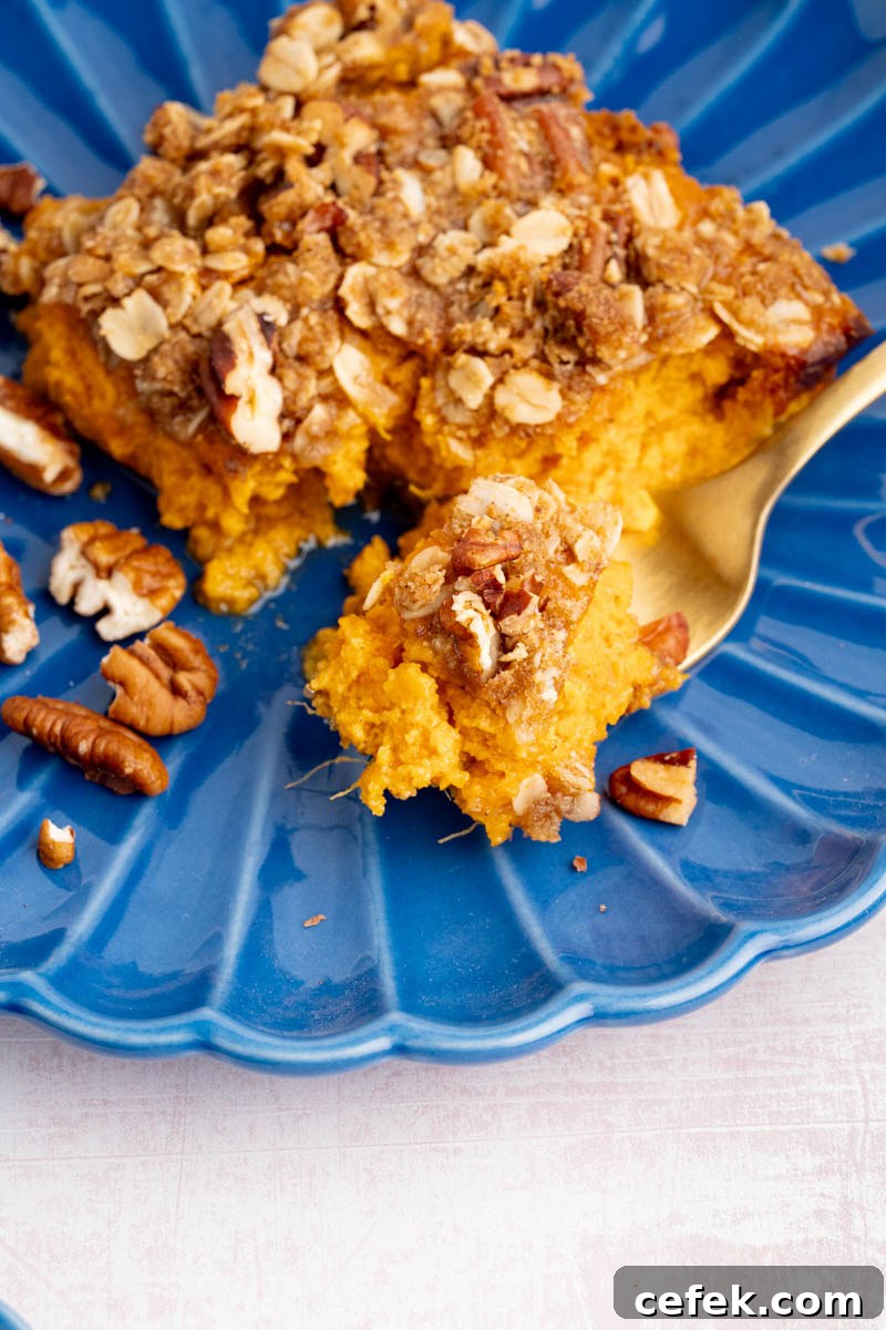 A fork with some of the sweet potato casserole on it sits on a blue plate before serving.