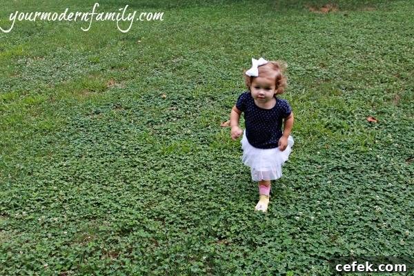 A young girl walking in a grass field.