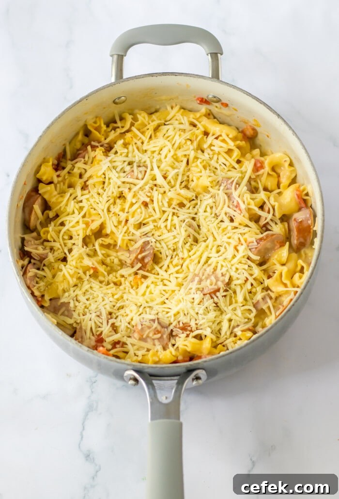 creamy sausage pasta cooked in skillet with cheese
