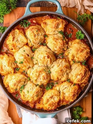 Catfish etouffee pot pie in a cast iron skillet, sitting on a wooden cutting board.