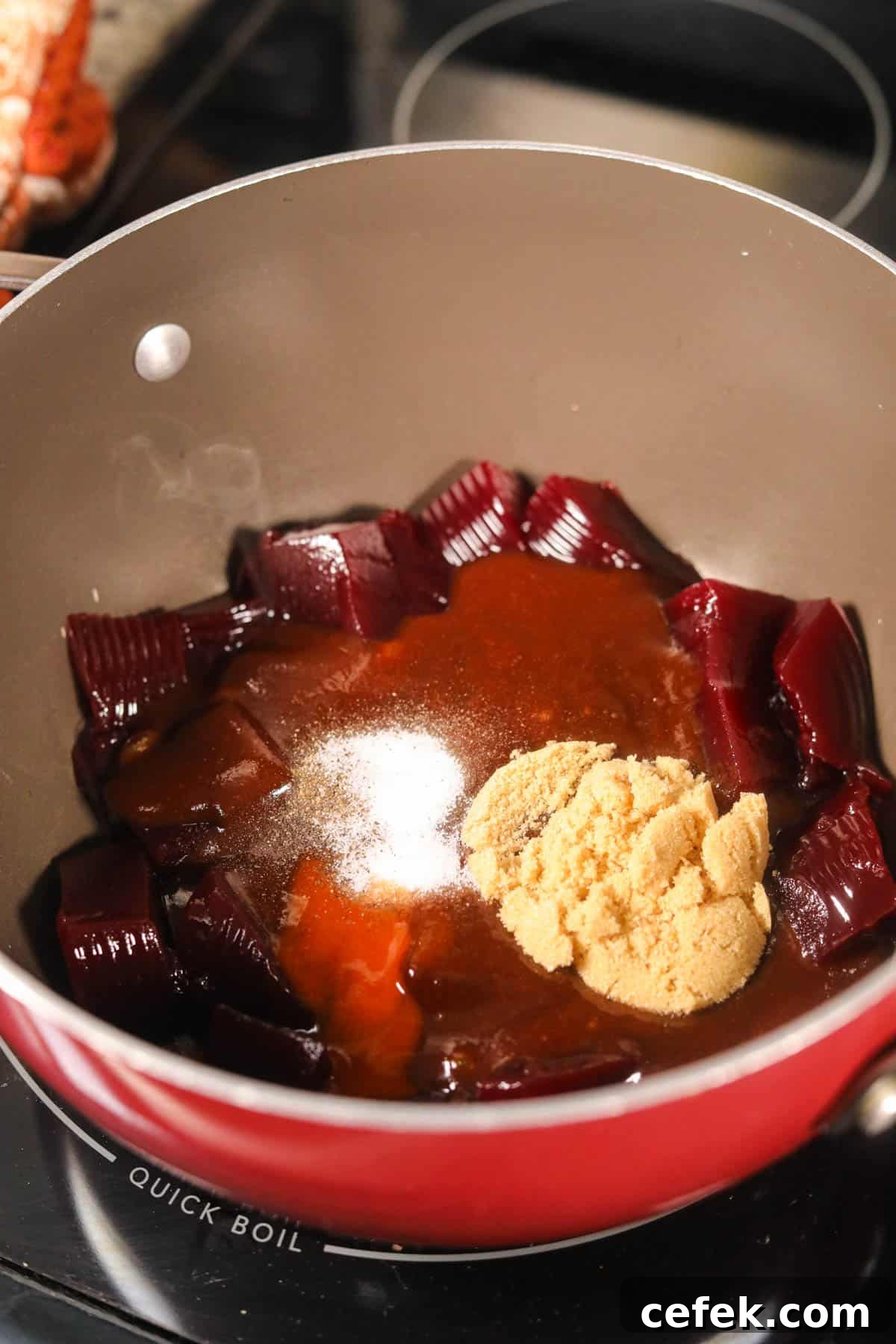 Cranberry barbecue sauce for meatballs, simmering in a sauce pan.