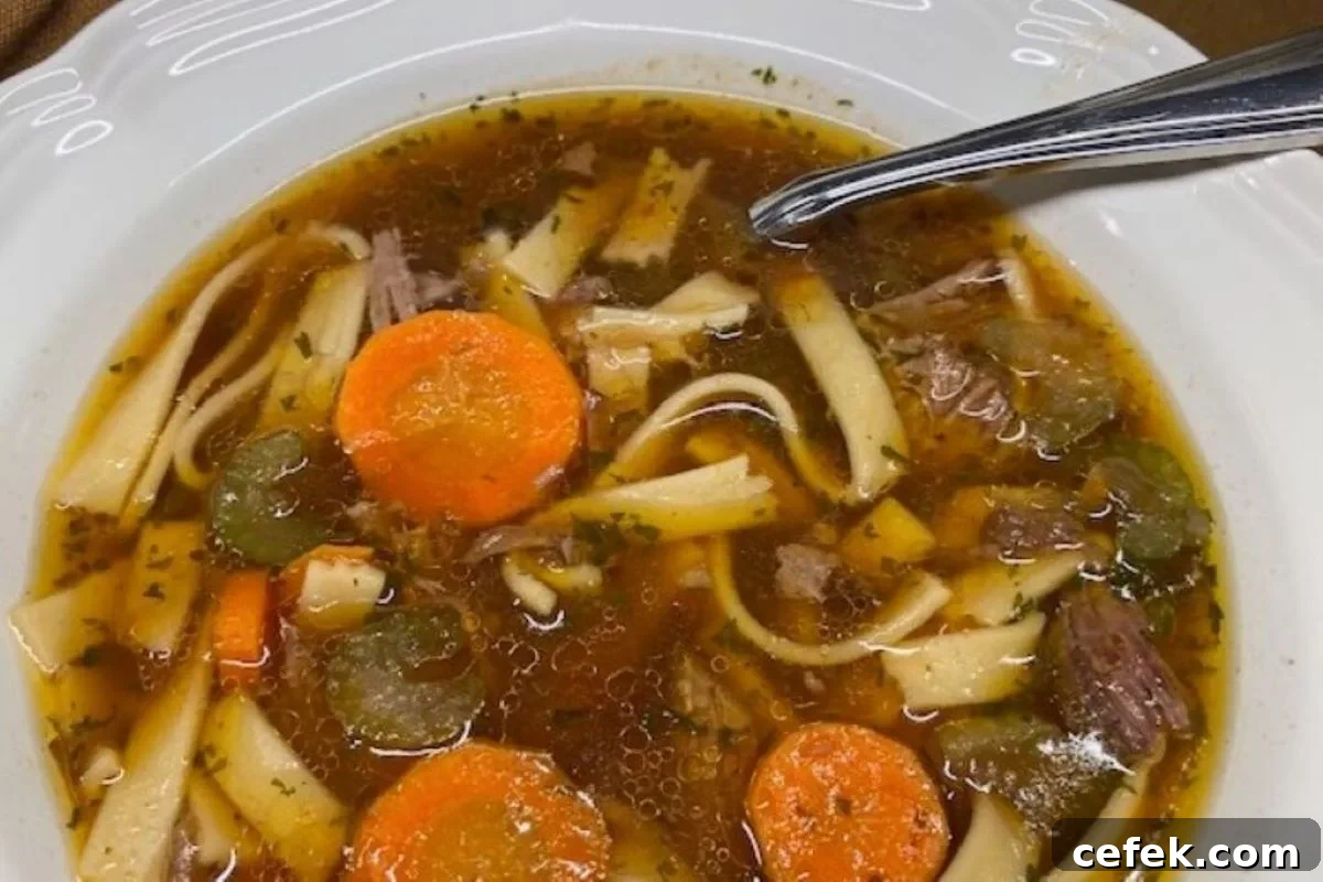 A hearty bowl of homemade beef noodle soup with tender chunks of beef, carrots, and egg noodles in rich broth — cozy comfort food from GB’s Kitchen.
