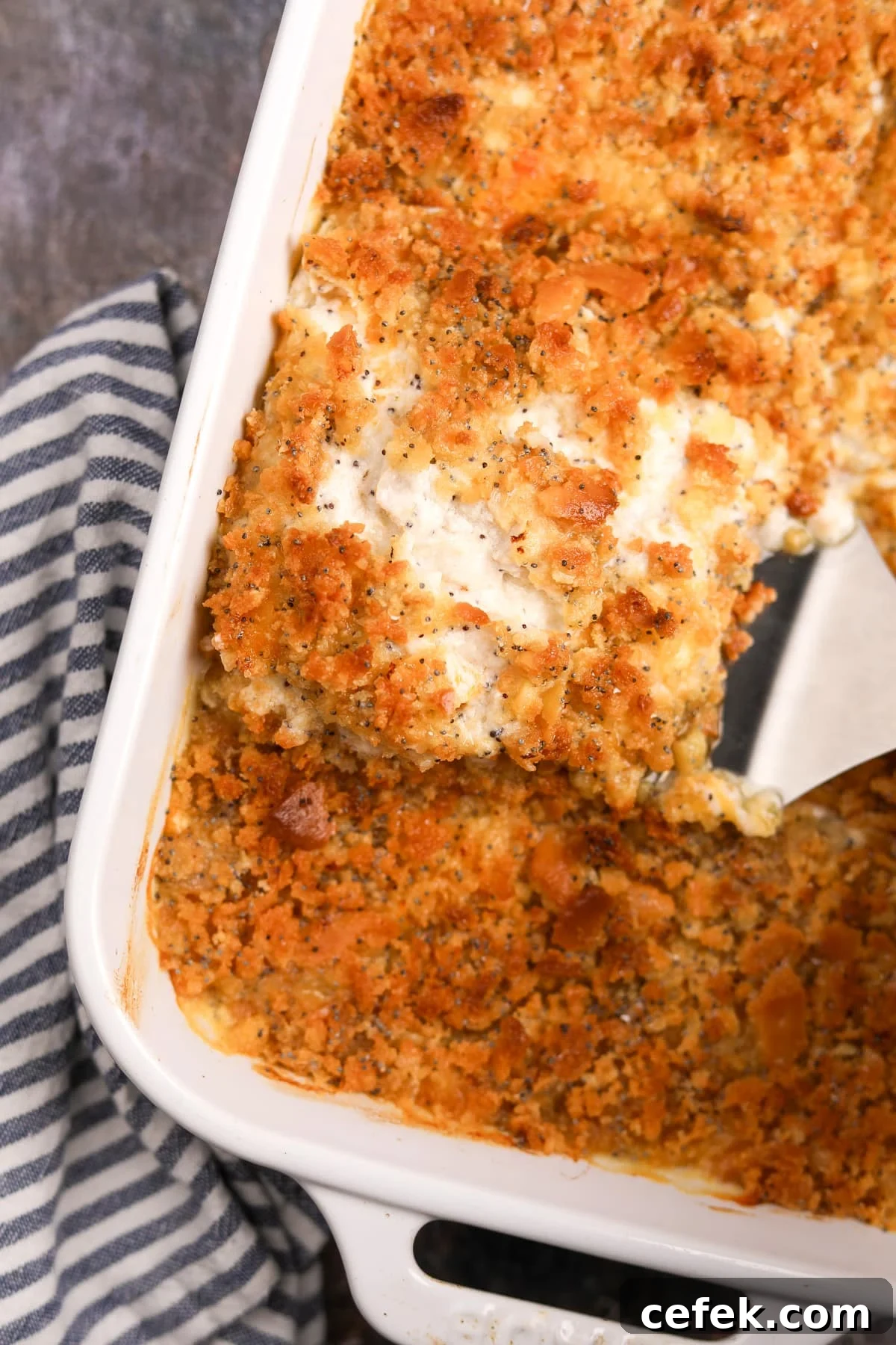 A spatula removing a portion of casserole from a baking dish.