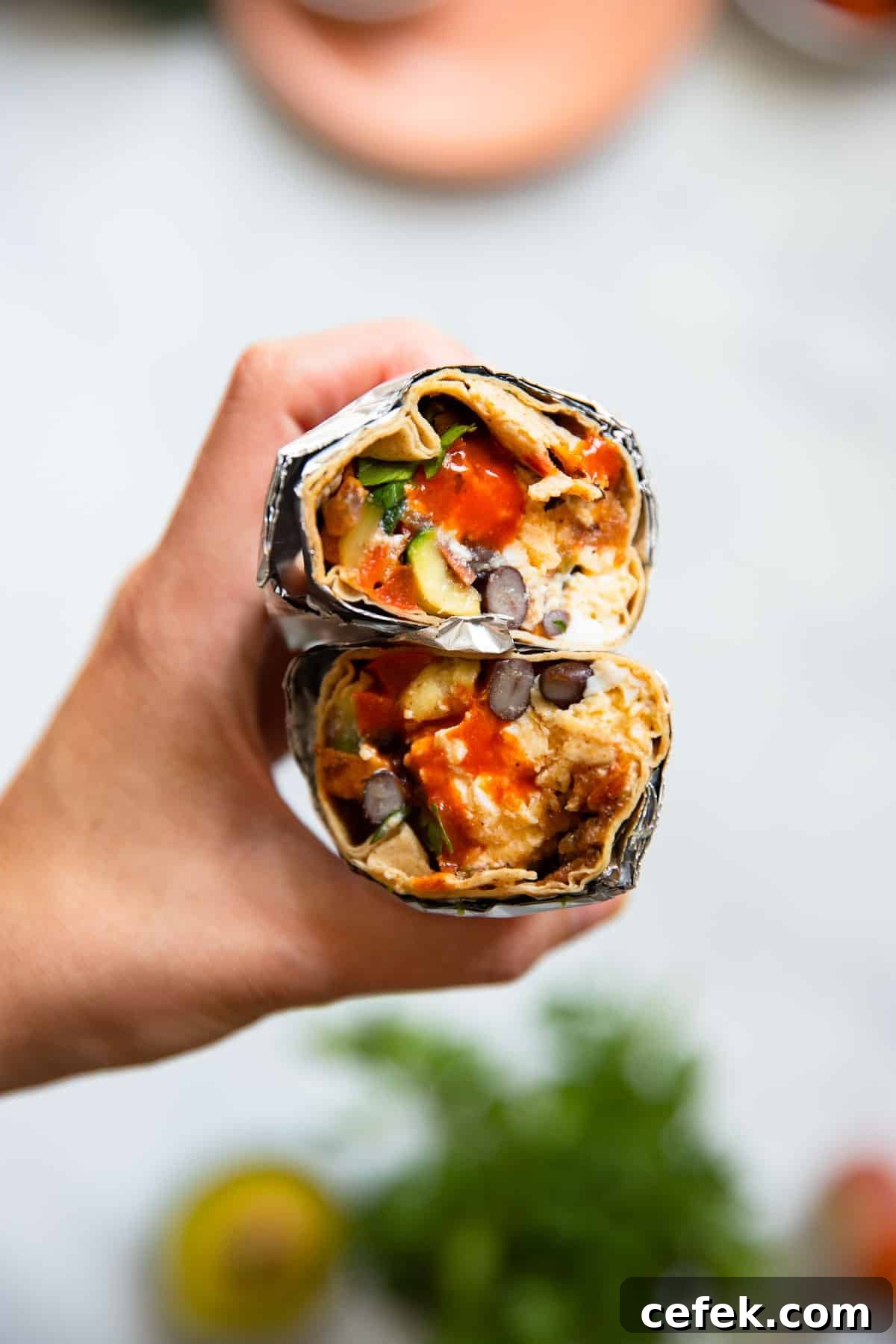 close up of a vegan breakfast burrito sliced in half. 
