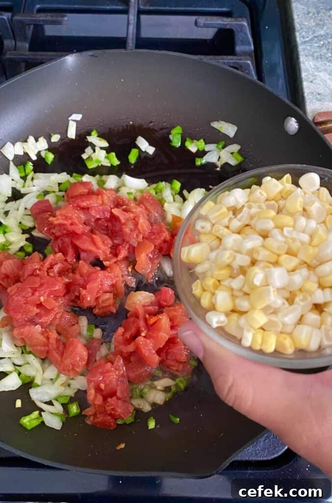 adding sweet corn to tomato sauté