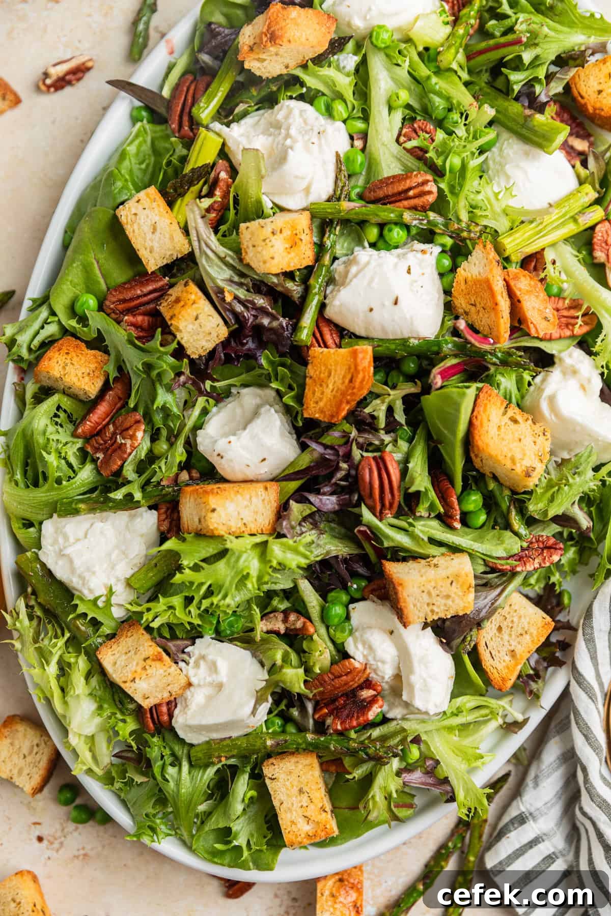 Overhead view of serving platter with spring green and burrata salad.