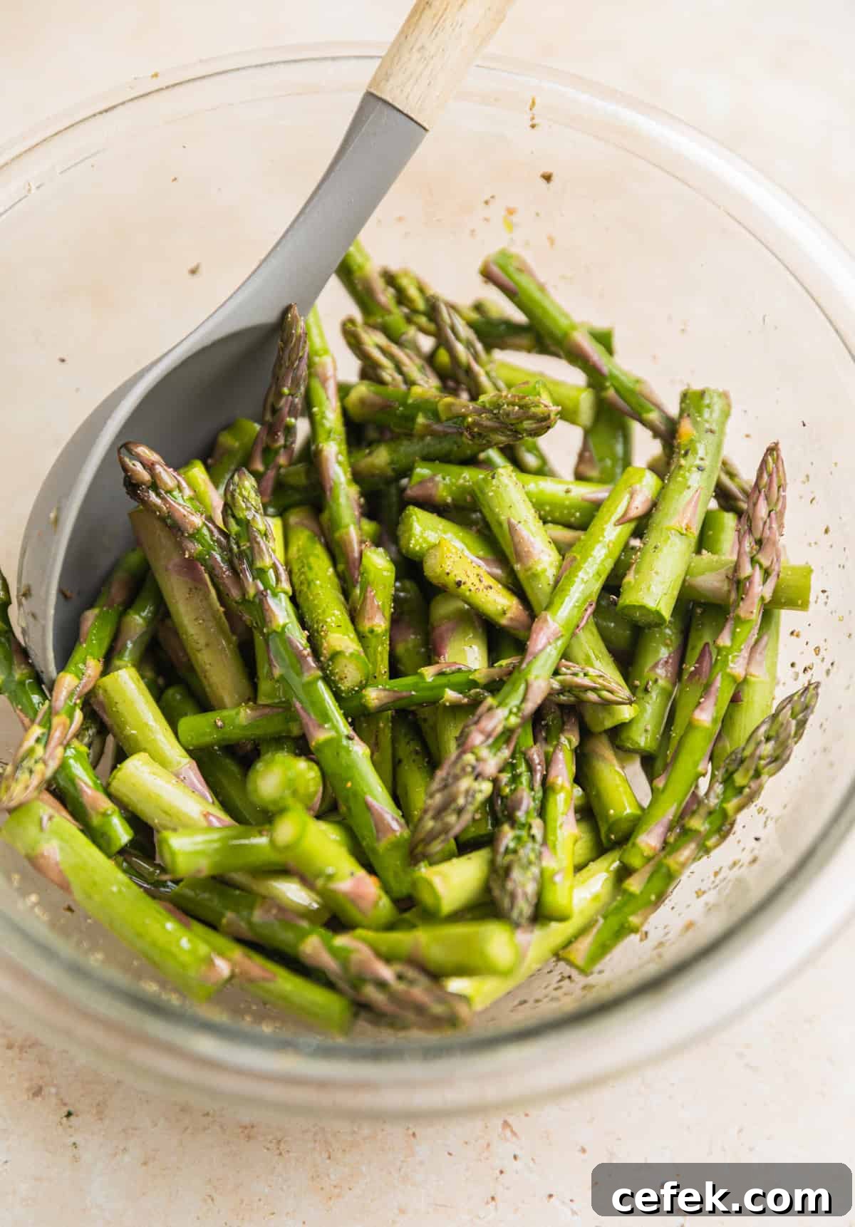 Asparagus pieces in bowl with spoon.