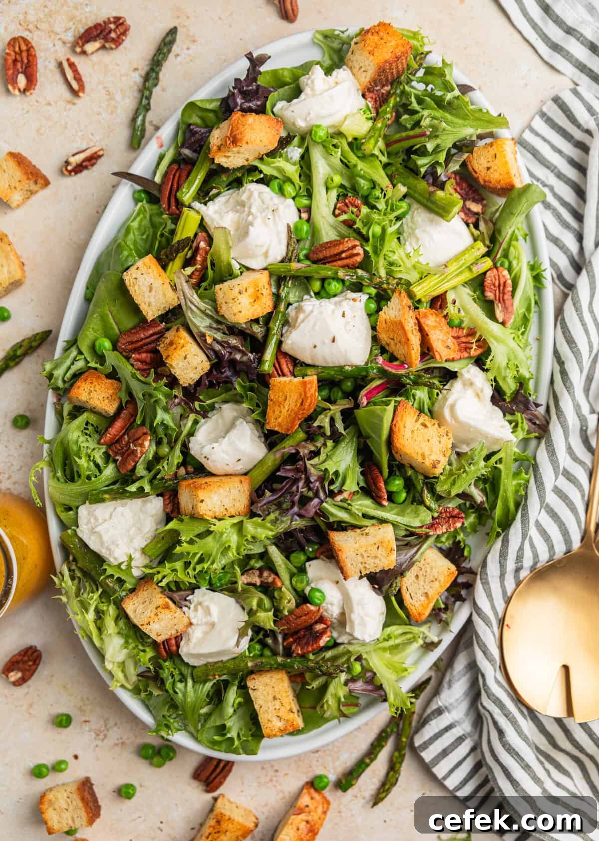 Burrata salad with croutons, pecans and asparagus on plate.