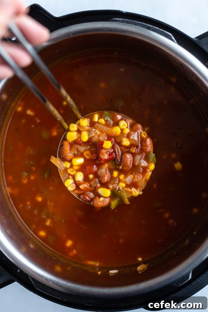 scoop of vegetarian chili being pulled out of an instant pot