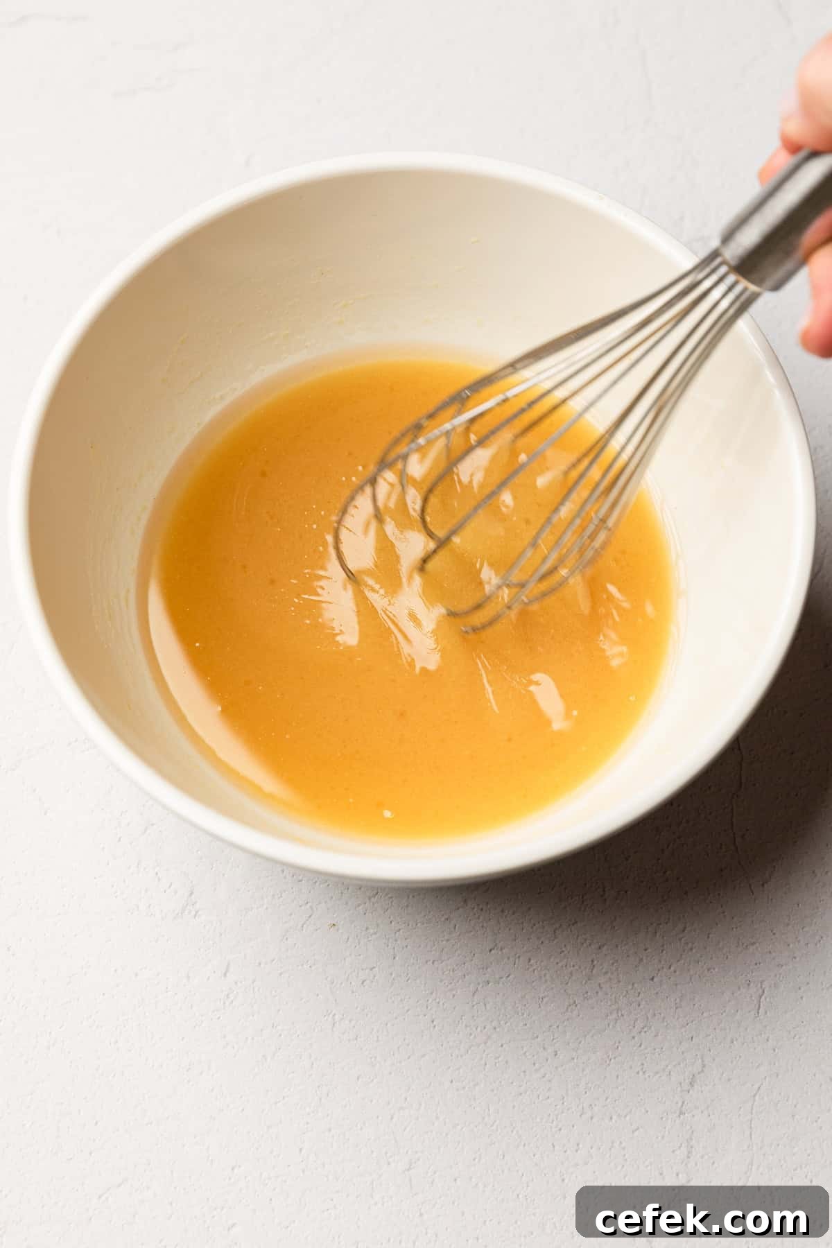 Whisking ingredient together to make salad dressing.
