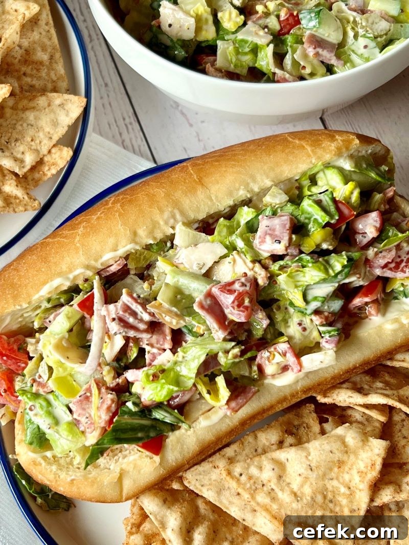 Italian chopped salad prepared and stuffed in soft hoagie rolls with a side of nacho tortilla chips.