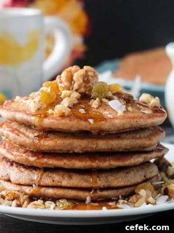 Close up of maple syrup drizzling down the side of a stack of carrot cake pancakes.