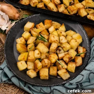 Parmentier Potatoes served on a grey plate with fresh rosemary leaves on top