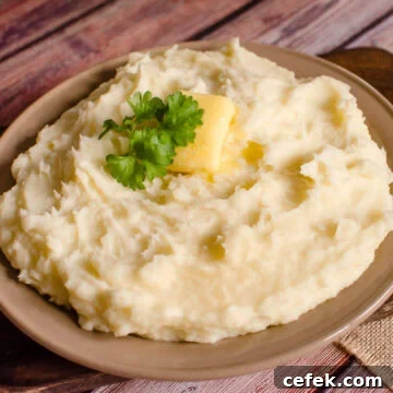 Mashed Potatoes served in a brown bowl with butter and parsley on top