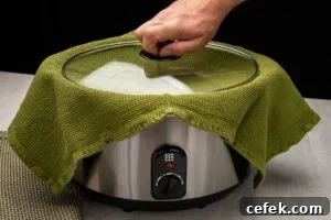 Placing the lid on top of the towel and slow cooker