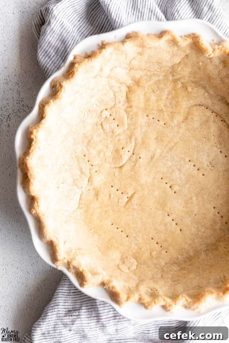 Close up shot of Gluten-Free Almond Flour Pie Crust baked in white pie plate.
