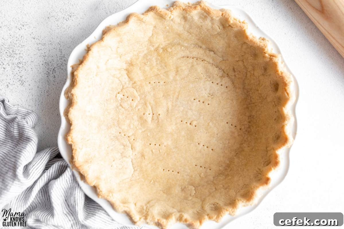 Gluten-Free Almond Flour Pie Crust in white pie plate with striped towel.