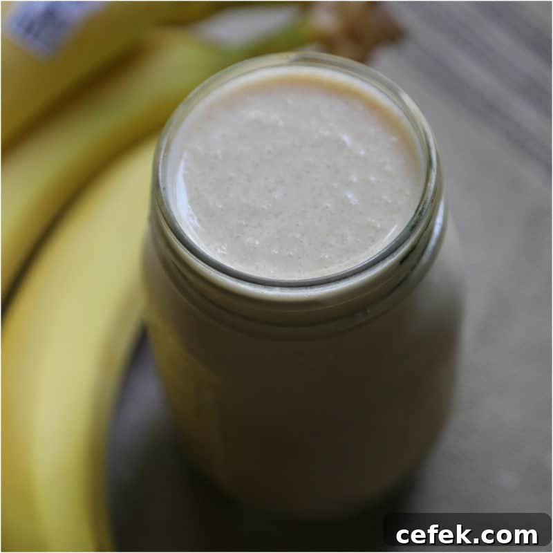 Peanut Butter Banana Smoothie in a mason jar next to bananas