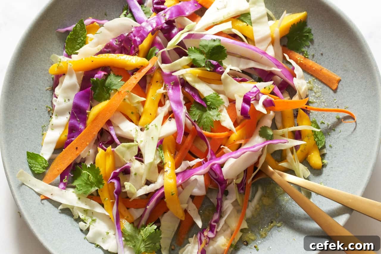 A plate of mango slaw with two gold utensils on it.