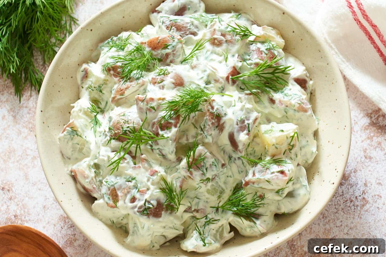 A bowl of dill potato salad topped with chopped fresh dill.