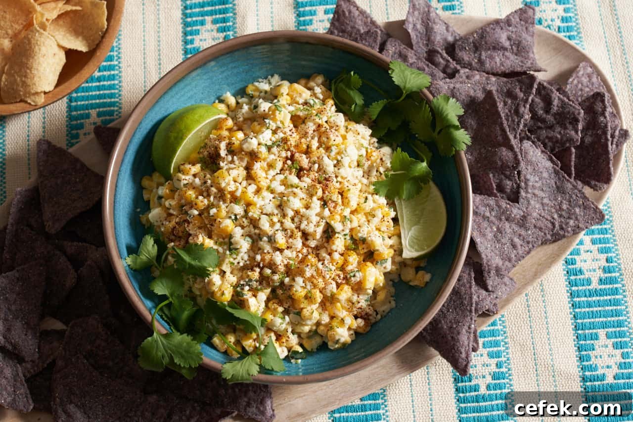 Elote dip in a blue bowl topped with cotija cheese.