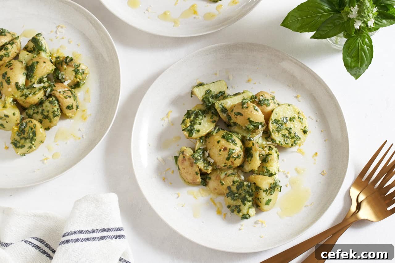 Two white plates with pesto potato salad.