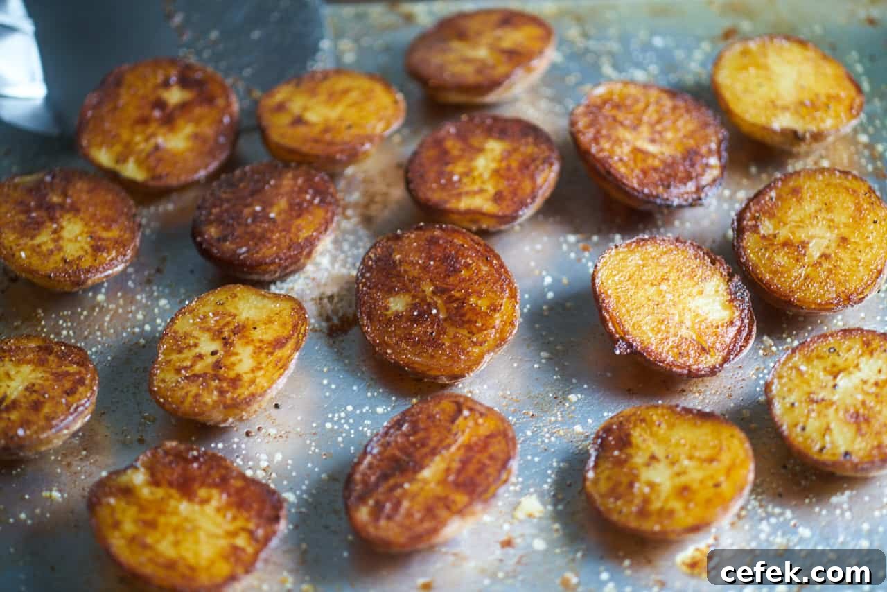 Crispy roasted potatoes seasoned with salt and pepper on a sheet tray.