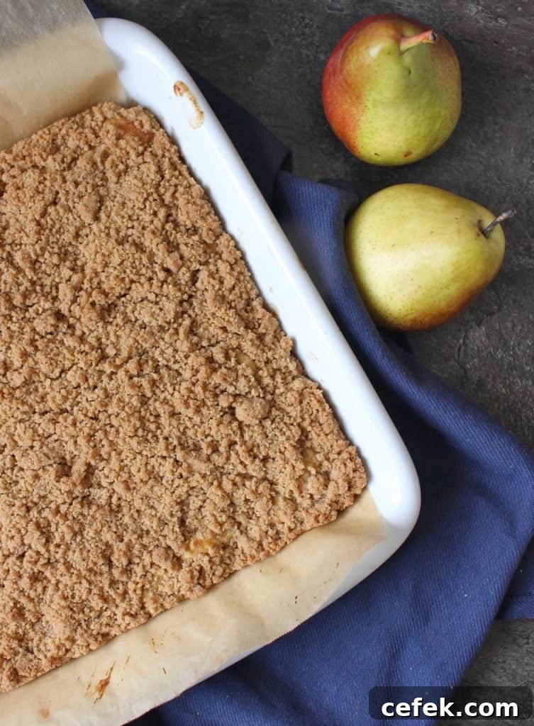 Crumble Cake from above next to two fresh pears.