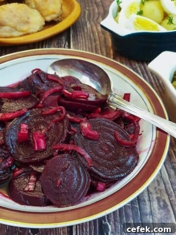 A dish of spicy beetroot salad on a table with other salads.