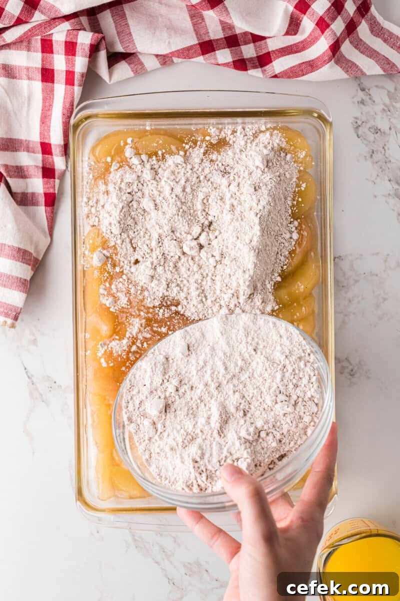 sprinkling the cake mix on top of the apple pie filling.