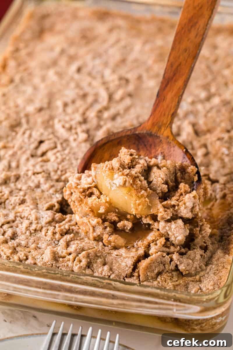 serving the Apple Spice Dump Cake with a wooden serving spoon.