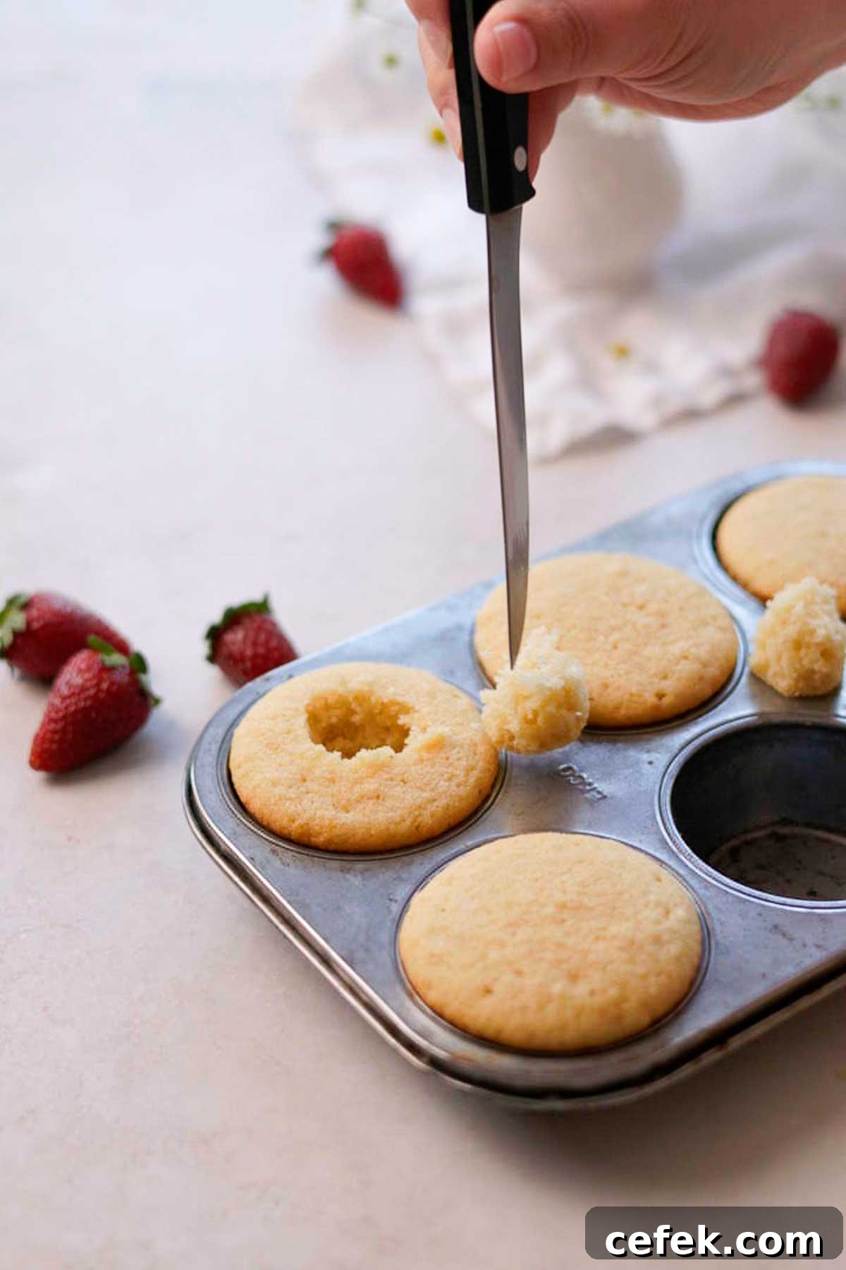 cutting out the centre of the cupcake with a knife