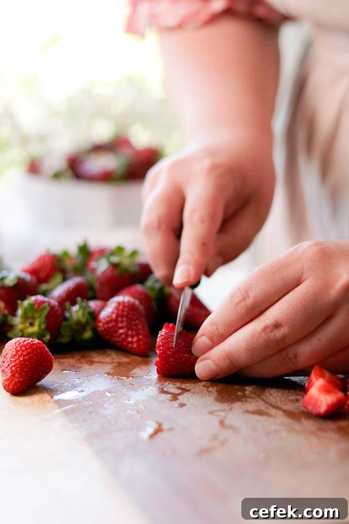 cutting the strawberries into little pieces with a knife