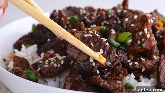 serving Mongolian Beef in white bowl with chopsticks