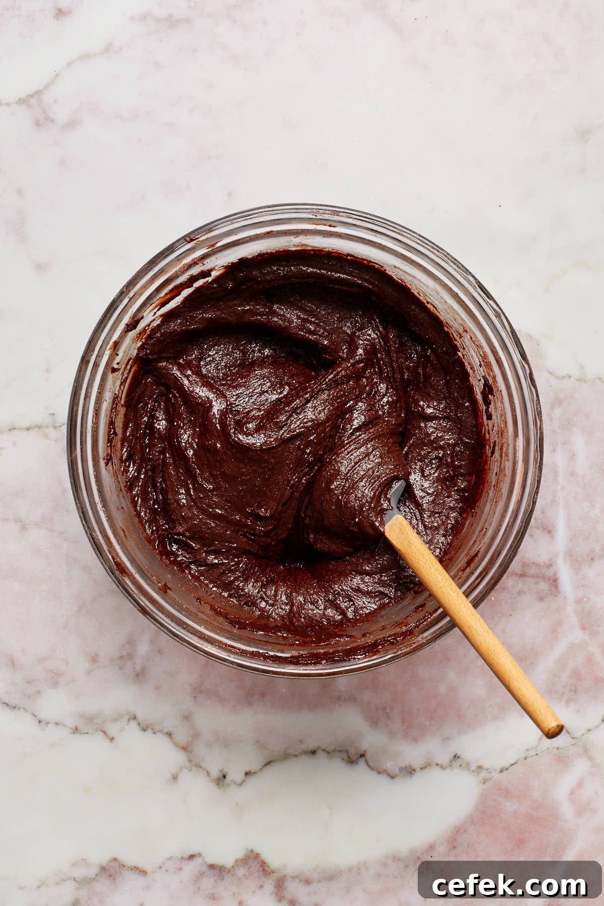 Batter stirred together with a spatula in a glass bowl.