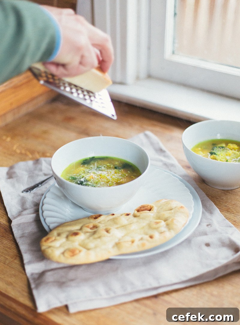 grating parmesan on the chicken quinoa kale soup