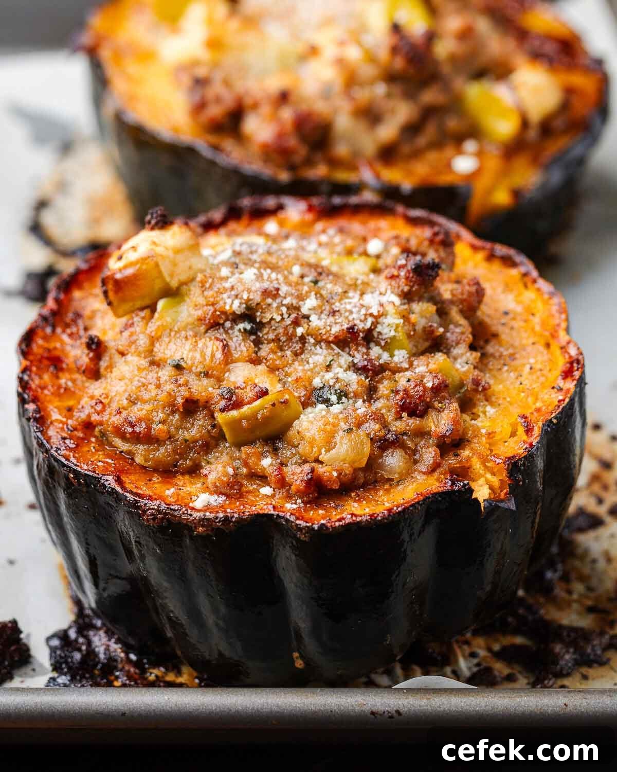 Sausage stuffed acorn squash on baking sheet.