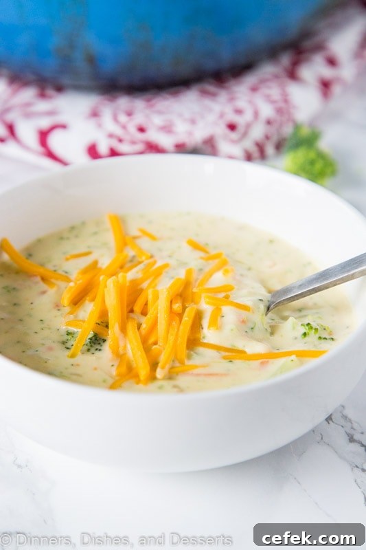 A bowl of broccoli cheese soup with spoon