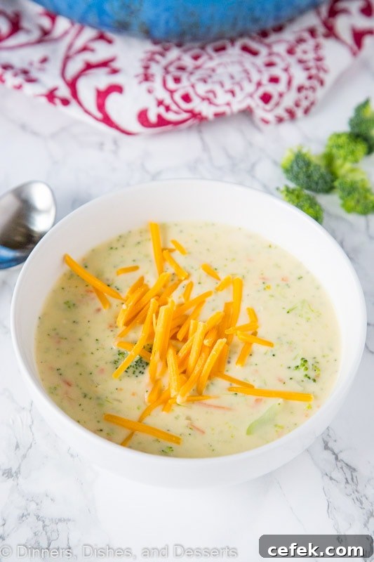 A bowl of broccoli cheese soup with cheese on top
